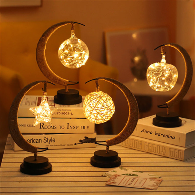 4 of warm light moon shaped night lamps on table and books