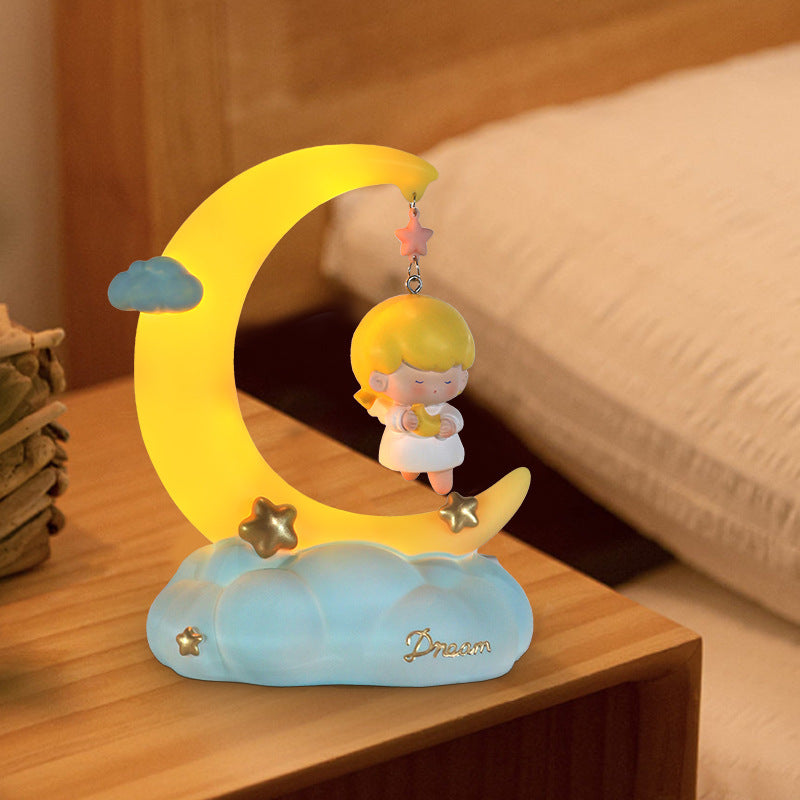 Moon shaped little angel night lamp on the bedside table
