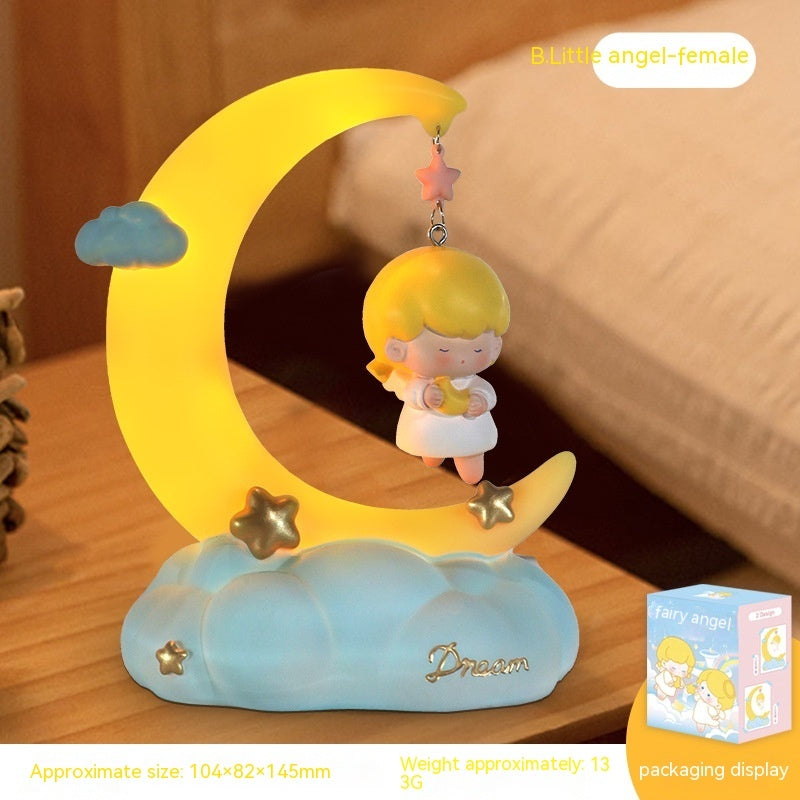 Moon shaped bedside lamp with little angel on the bedside table