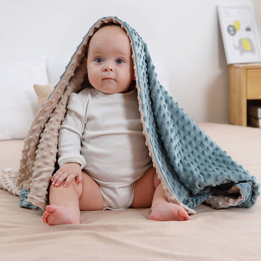 A baby with a blue pink blanket on the head