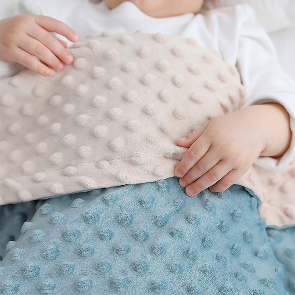 a baby hands holding pink blue baby blanket