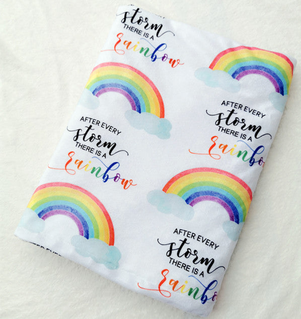 Folded rectangular shaped baby blanket with rainbows