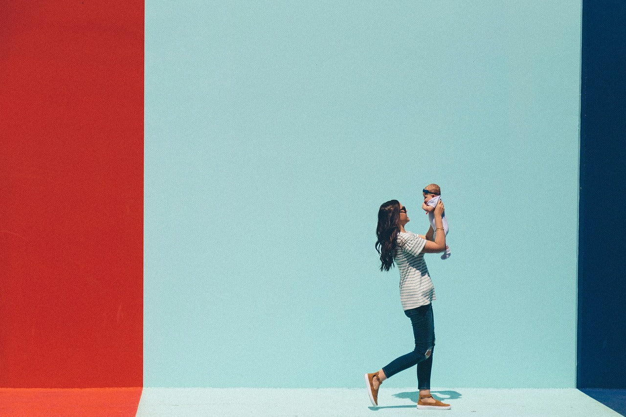 mother holding a child on the light blue background