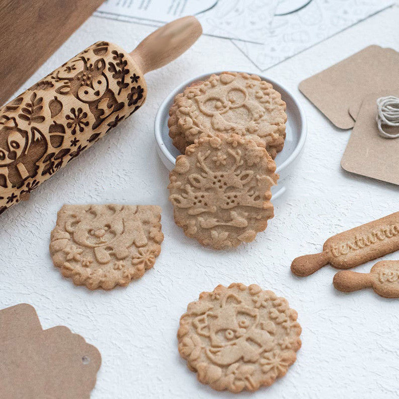 rolling pin with some cookies on the table